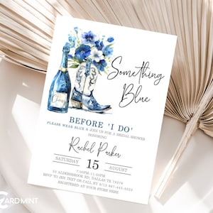 May include: A blue and white bridal shower invitation with a watercolor illustration of a bouquet of flowers, a bottle of champagne, and a pair of cowboy boots. The text reads "Something Blue" and "Before 'I Do'".