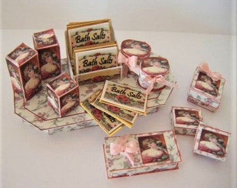 May include: A miniature display of bath salts in decorative boxes and containers. The boxes are decorated with floral patterns and images of women. The boxes are arranged on a tray with a floral pattern.