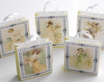 May include: Five small, white gift bags with yellow paper lining and white ribbon handles. Each bag features a vintage illustration of a woman in a dress with a floral design.