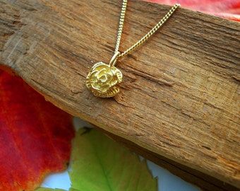 Peut inclure: Un collier en chaîne dorée avec un pendentif en forme de rose texturé. Le pendentif est un design détaillé en trois dimensions.