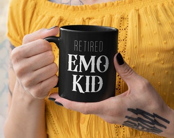 May include: A black coffee mug with white text that reads "Retired Emo Kid".