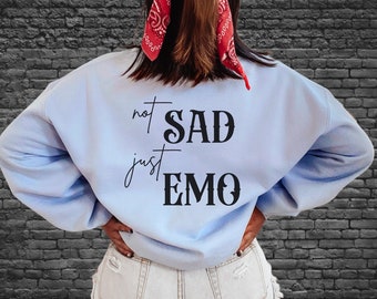 May include: A light blue sweatshirt with the text "not SAD just EMO" printed on the back.