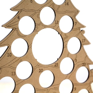 May include: A brown wooden Christmas tree ornament holder with 25 numbered circles for holding ornaments. The tree is made of plywood and has a rustic look.