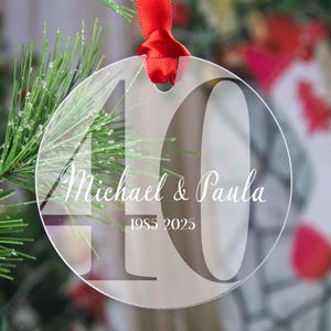 May include: Clear glass Christmas ornament with the number 40 printed in black. The text "Michael & Paula 1985-2025" is printed in white on the ornament.