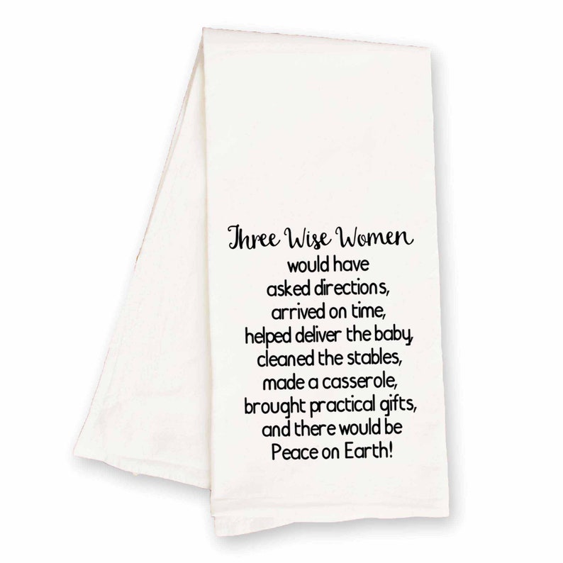 May include: White kitchen towel with black text that reads "Three Wise Women would have asked directions, arrived on time, helped deliver the baby, cleaned the stables, made a casserole, brought practical gifts, and there would be Peace on Earth!"