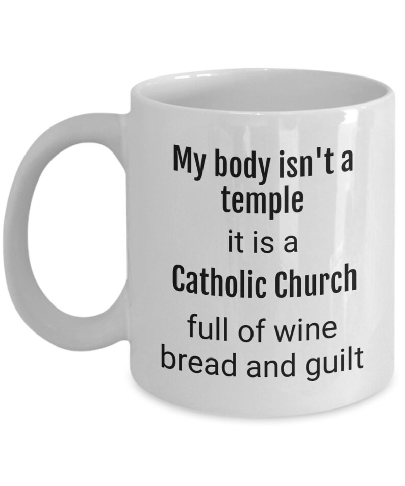 May include: White ceramic coffee mug with a black text design that reads "My body isn't a temple it is a Catholic Church full of wine bread and guilt"