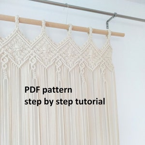 Peut inclure: Une suspension murale en macramé blanche avec un motif géométrique. La suspension est fixée à une baguette en bois. Le texte "PDF pattern step by step tutorial" est visible sur la suspension.