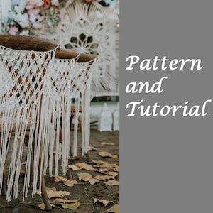 May include: Two wooden chairs with white macrame chair backs and fringe. The chairs are set up outdoors on a brick patio with fallen leaves.