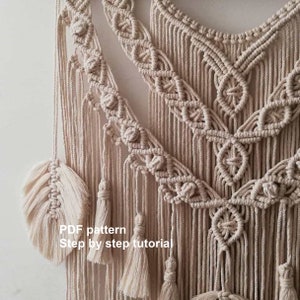 Peut inclure: Une suspension murale en macramé beige avec un motif géométrique et des glands. Le texte "PDF pattern Step by step tutorial" est visible en bas de l'image.