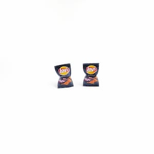 May include: Two miniature bags of Lay's Barbecue potato chips. The bags are black with red and white lettering. The bags are on a white background.
