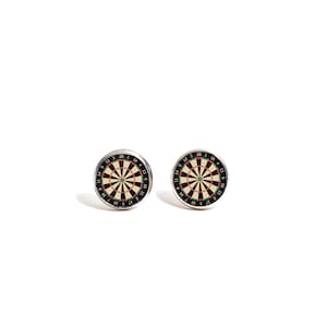 May include: A pair of silver stud earrings with a black and white dartboard design. The dartboard has red and green accents.