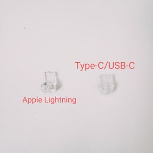 Puede incluir: Primer plano de dos extremos de conectores de pl&aacute;stico transparente para cables de carga. El conector de la izquierda est&aacute; etiquetado como "Apple Lightning" y el conector de la derecha est&aacute; etiquetado como "Type-C/USB-C".
