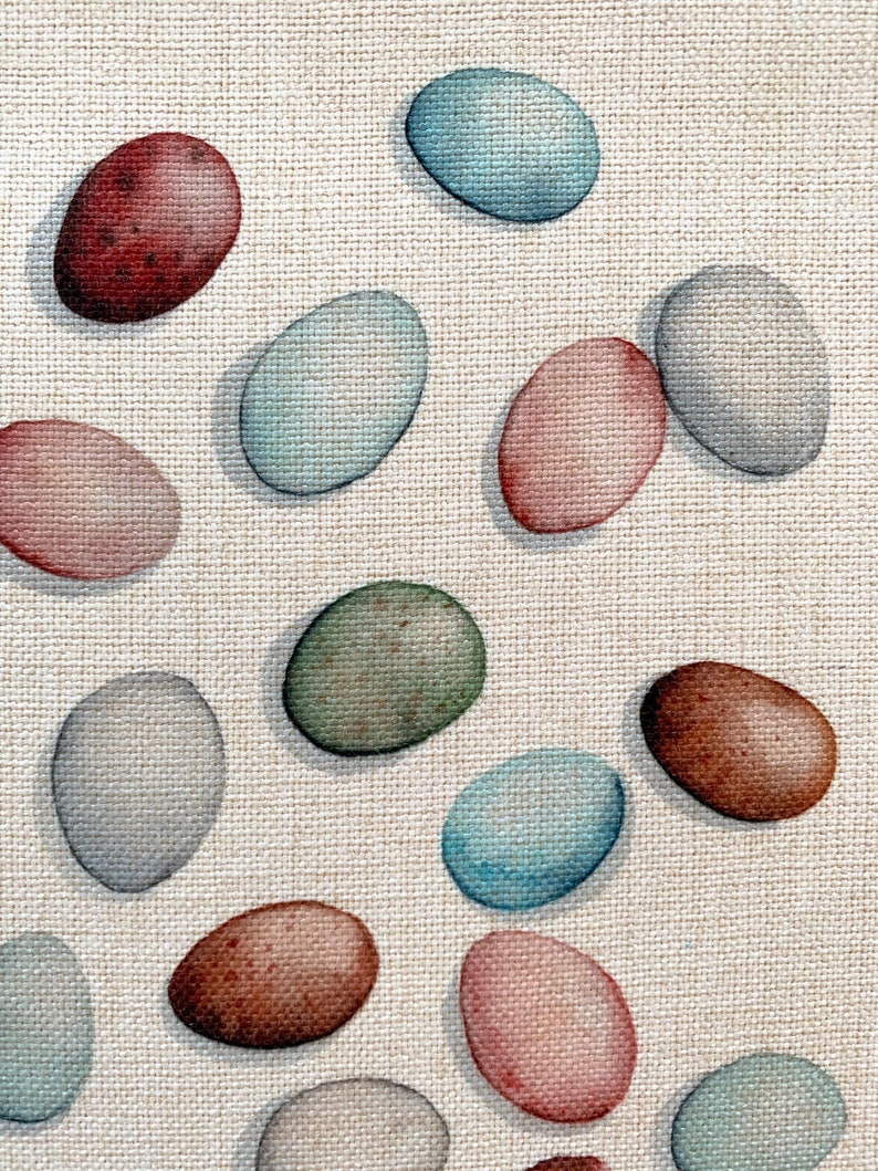 Op de afbeelding: Een verzameling van 14 geschilderde ovale eieren in verschillende kleuren, waaronder blauw, groen, bruin en roze, op een beige textuur achtergrond.