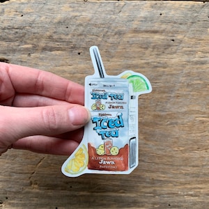 May include: A sticker of a cartoon illustration of a carton of Fishtown Iced Tea with a lemon slice and a straw. The carton is blue and white with the text "Fishtown Iced Tea" and "A Lemon Flavored Jawn" in black. The text "PT (413mL)" is also visible.