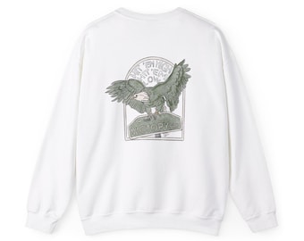 Könnte beinhalten: Weißer Langarm-Pullover mit einem Grafikdruck eines Adlers, der über einem Schild fliegt, auf dem "Hit 'em High Hit 'em Low Victory Rd." steht.