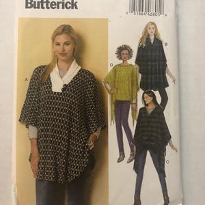 Può includere: Cartamodello Butterick B6391 per poncho in taglia Y (Xsm-Sml-Med). La busta presenta illustrazioni di quattro varianti di poncho etichettate A, B, C e D, che mostrano diversi motivi, colori e scollature, tra cui un collo a scialle e frange.