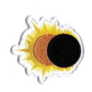 Könnte beinhalten: Gestickter Aufnäher mit einem Sonnenfinsternis-Design. Der Aufnäher hat ein schwarzes, braunes und gelbes Farbschema mit einem weißen Rand. Die Sonne wird teilweise vom Mond verdeckt, wodurch ein himmlisches Thema entsteht.