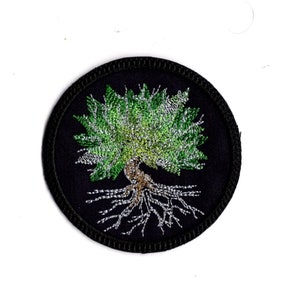May include: A black embroidered patch with a green tree with silver roots on a black background.