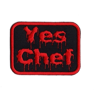Op de afbeelding: Rode geborduurde patch met de woorden "Yes Chef" in een druppelend lettertype op een zwarte achtergrond met een rode rand.