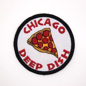 May include: A white round patch with a black border. The patch has red text that says "Chicago Deep Dish" and a red and yellow pizza slice with red pepperoni.