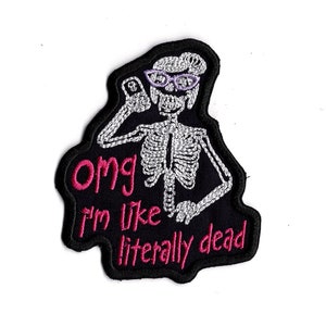 May include: Iron-on patch featuring an embroidered skeleton wearing glasses and holding a phone, with the text "Omg I'm like literally dead" in pink.