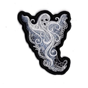 May include: Embroidered patch with a ghost design. The ghost is white and light blue with detailed swirling patterns, set against a black border. Suitable for application on clothing or accessories.