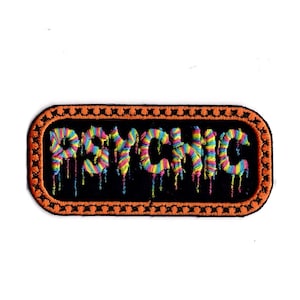 Könnte beinhalten: Ein gestickter schwarzer und orangefarbener Aufnäher mit dem Wort "PSYCHIC" in Regenbogenfarben, das mit bunter Farbe tropft.