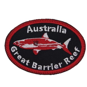Op de afbeelding: Rode en witte geborduurde patch met een haai-silhouet en de tekst "Australië Great Barrier Reef".