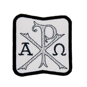 Op de afbeelding: Witte geborduurde patch met een zwarte rand. De patch heeft een zilveren geborduurd Chi Rho-symbool met de Griekse letters Alpha en Omega aan weerszijden.