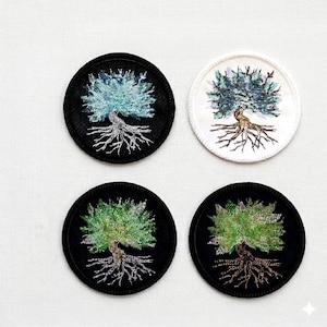 Könnte beinhalten: Vier gestickte Aufnäher mit einem Baumdesign. Zwei Aufnäher haben einen schwarzen Hintergrund, einer mit einem blau-grünen Baum und der andere mit einem grünen Baum. Die anderen beiden Aufnäher haben einen weißen Hintergrund, einer mit einem blau-grünen Baum und der andere mit einem grünen Baum.