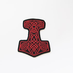 Könnte beinhalten: Ein gestickter schwarzer und roter Aufnäher mit einem stilisierten Mjolnir, dem Hammer von Thor, in einem keltischen Knotendesign.
