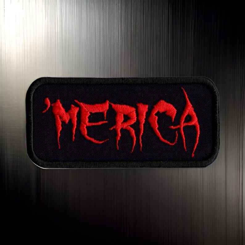 May include: Red embroidered patch with the word "'MERICA" in a stylized font on a black background.