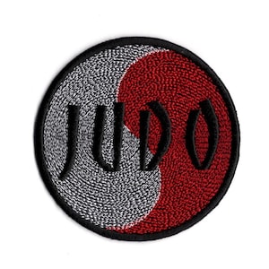 May include: A black and red embroidered patch with the word "JUDO" in black lettering. The patch is circular and features a yin-yang symbol.