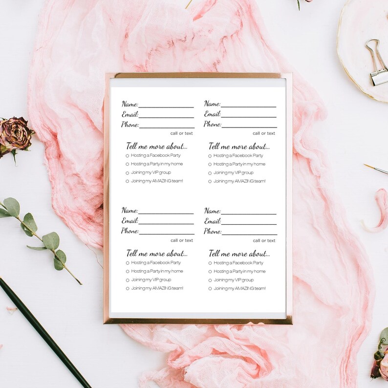 May include: A set of four white business cards with a gold border, featuring fields for name, email, and phone, along with checkboxes for event options. The cards are on a pink fabric background.