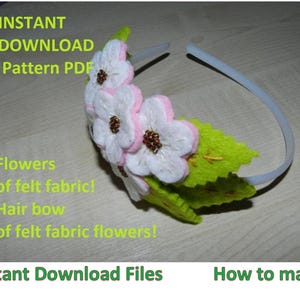 May include: A white felt flower headband with green felt leaves. The headband is made of a white plastic material. The flowers are pink and white with brown centres. The text "Instant Download Pattern PDF" is visible in the image.