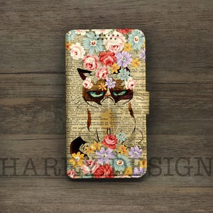 May include: A phone case featuring a grumpy cat design with a floral crown. The case has a vintage book page background and a magnetic closure. The design includes a variety of colorful flowers.