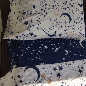 K&ouml;nnte beinhalten: Ein wei&szlig;-blaues Bettw&auml;sche-Set mit einem Sternen- und Halbmondmuster. Die Bettw&auml;sche ist aus weichem, bequemem Stoff gefertigt und perfekt, um jedem Schlafzimmer einen Hauch von Verspieltheit zu verleihen.