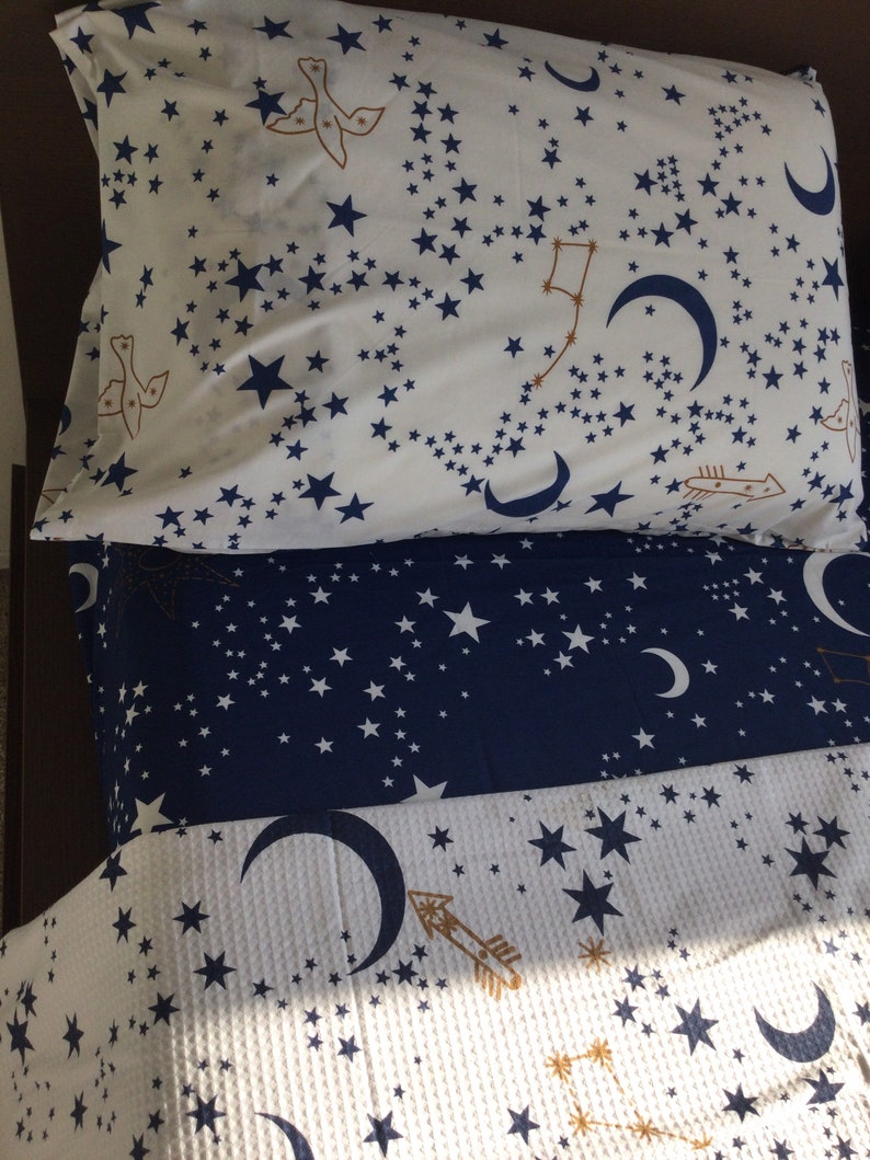 K&ouml;nnte beinhalten: Ein wei&szlig;-blaues Bettw&auml;sche-Set mit einem Sternen- und Halbmondmuster. Die Bettw&auml;sche ist aus weichem, bequemem Stoff gefertigt und perfekt, um jedem Schlafzimmer einen Hauch von Verspieltheit zu verleihen.