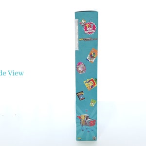 May include: A blue cardboard box with the words "5 Surprise Mini Brands!" and a picture of a shopping cart filled with miniature versions of popular brands. The box is decorated with images of various mini brands, including a Rubik's Cube, a mini cereal box, and a mini bottle of hand sanitizer.