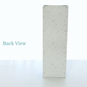 May include: A white box with a speckled pattern. The box is standing upright on a white surface. The text "Back View" is visible in the background.