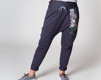 Pantalon baggy "Gris" En tissu de coton gris avec une poche double face colorée avec des fleurs. L'impression a été créée spécialement pour ce style.
