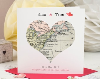 May include: A white card with a heart-shaped map of North America on it. The card says "Sam & Tom" and "28th May 2016 Congratulations on your wedding".