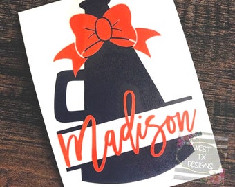 May include: A blue megaphone with an orange bow on top. The word "Madison" is written in orange across the bottom of the megaphone.