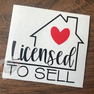 May include: White sticker with a black outline of a house and a red heart inside. The words "Licensed to Sell" are written in black cursive font below the house graphic.