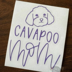 May include: Purple vinyl decal with a white outline of a cavapoo dog's head and the text "Cavapoo Mom" in a cursive font.
