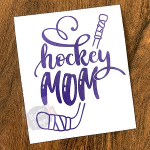 Puede incluir: Calcomanía de vinilo morado con el texto "hockey MOM" y un palo de hockey estilizado.