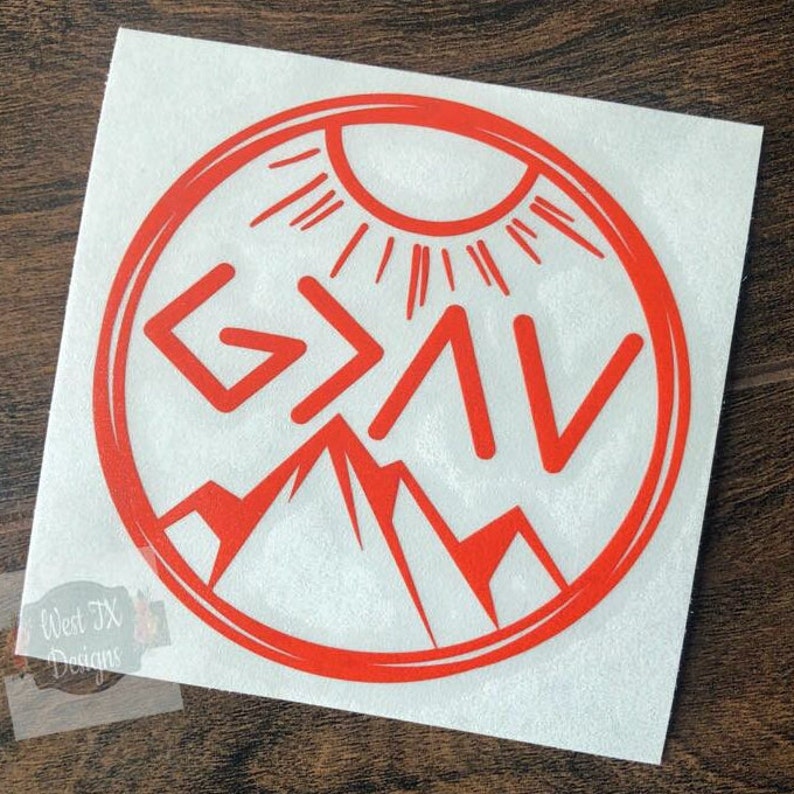 May include: Red vinyl decal with a circle design featuring a sun, mountains, and the words "God is Greater Than the Highs and Lows".