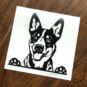May include: Black and white silhouette of an Australian Shepherd dog peeking over a surface with its tongue sticking out. The dog has a happy expression.