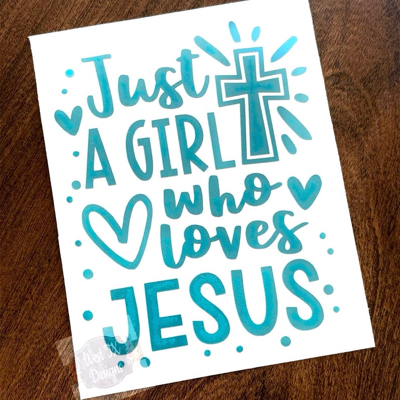 May include: White paper with the text "Just a GIRL who loves JESUS" in teal script. A cross and hearts are incorporated into the design. The words are surrounded by teal dots.