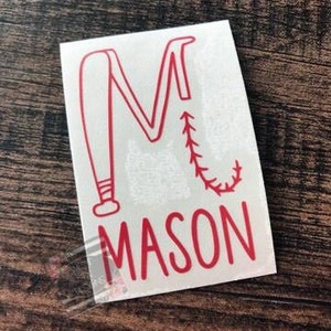 May include: Red vinyl decal with a baseball bat and a stitched baseball forming the letter "M" and the name "MASON" below.